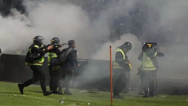 Aparat keamanan menembakkan gas air mata untuk menghalau suporter yang masuk lapangan usai pertandingan sepak bola BRI Liga 1 antara Arema melawan Persebaya di Stadion Kanjuruhan, Malang, Sabtu (1/10/2022). 