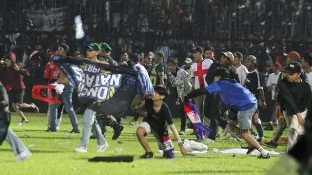 Suporter Arema FC memasuki lapangan setelah tim yang didukungnya kalah dari Persebaya dalam pertandingan sepak bola BRI Liga 1 di Stadion Kanjuruhan, Malang, Sabtu (1/10/2022).