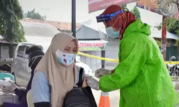 Petugas kesehatan menyuntikkan vaksin COVID-19 kepada warga