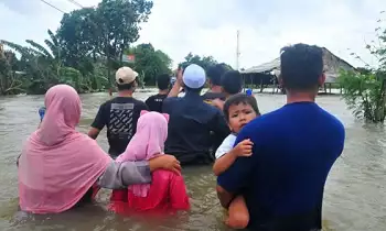 Sejumlah warga berjalan melintasi jalan yang terendam banjir di Desa Setrokalangan, Kudus, Jawa Tengah