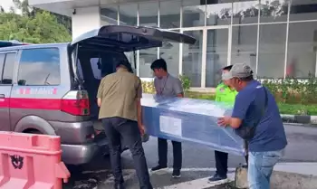 Salah satu jenazah WNI asal NTB dimasukkan ke dalam ambulans oleh staf KJRI Kuching di PLBN Entikong, Sambas, Kalimantan Barat