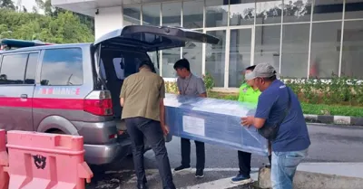 Salah satu jenazah WNI asal NTB dimasukkan ke dalam ambulans oleh staf KJRI Kuching di PLBN Entikong, Sambas, Kalimantan Barat