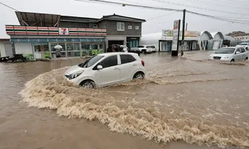 Sejumlah mobil melewati jalan yang banjir akibat hujan lebat di Cheongju, Korea Selatan