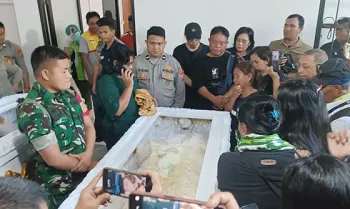 Keluarga korban Juliana Gumolung berdiri di pinggir peti jenazah sebelum diserahkan oleh pihak RS Bhayangkara Manado, Sulawesi Utara