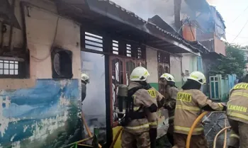 Petugas Gulkarmat memadamkan kebakaran pada sebuah warung makan, di Cilincing, Senin (21/7/2025) pagi