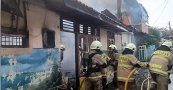 Petugas Gulkarmat memadamkan kebakaran pada sebuah warung makan, di Cilincing, Senin (21/7/2025) pagi
